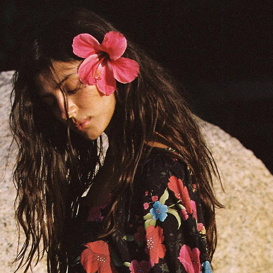 Model in the Spell Isola Gown in Midnight Bloom with a pink flower in her hair