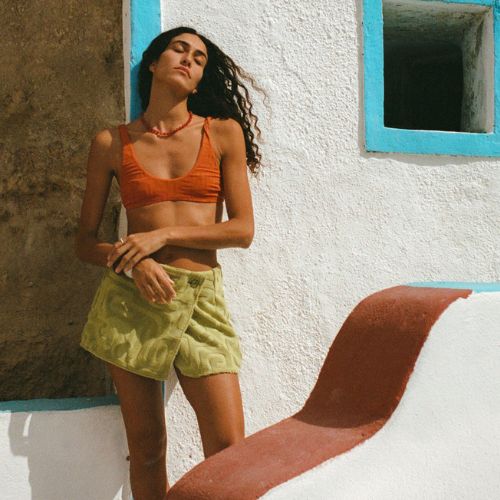 Woman wearing a white dress against a backdrop of bougenvellia