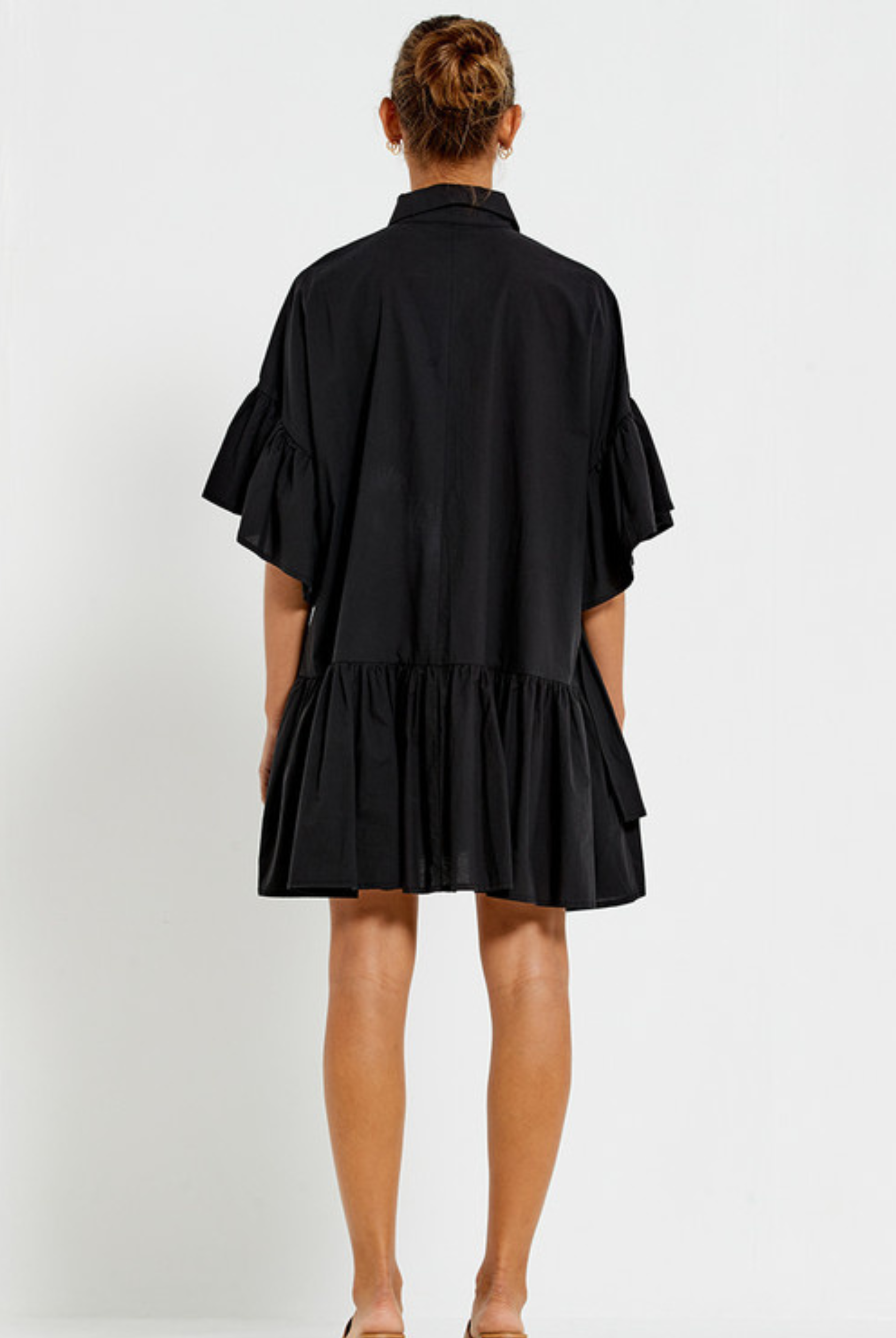 Model wearing the Bohemian Traders black Genoa Dress with button up front