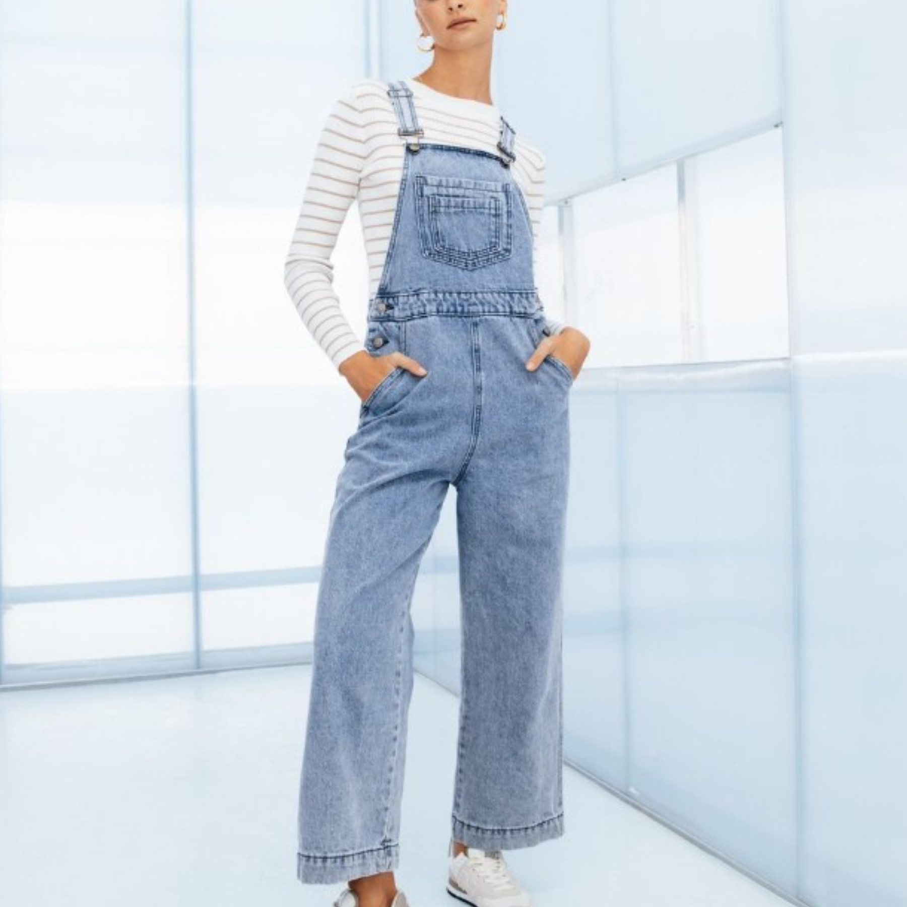 Model wearing lightwash denim overalls from paper heart