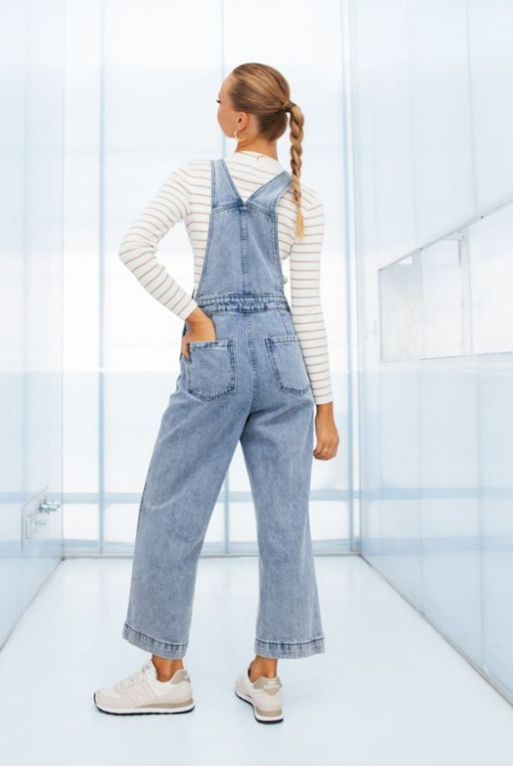 Model wearing lightwash denim overalls from paper heart