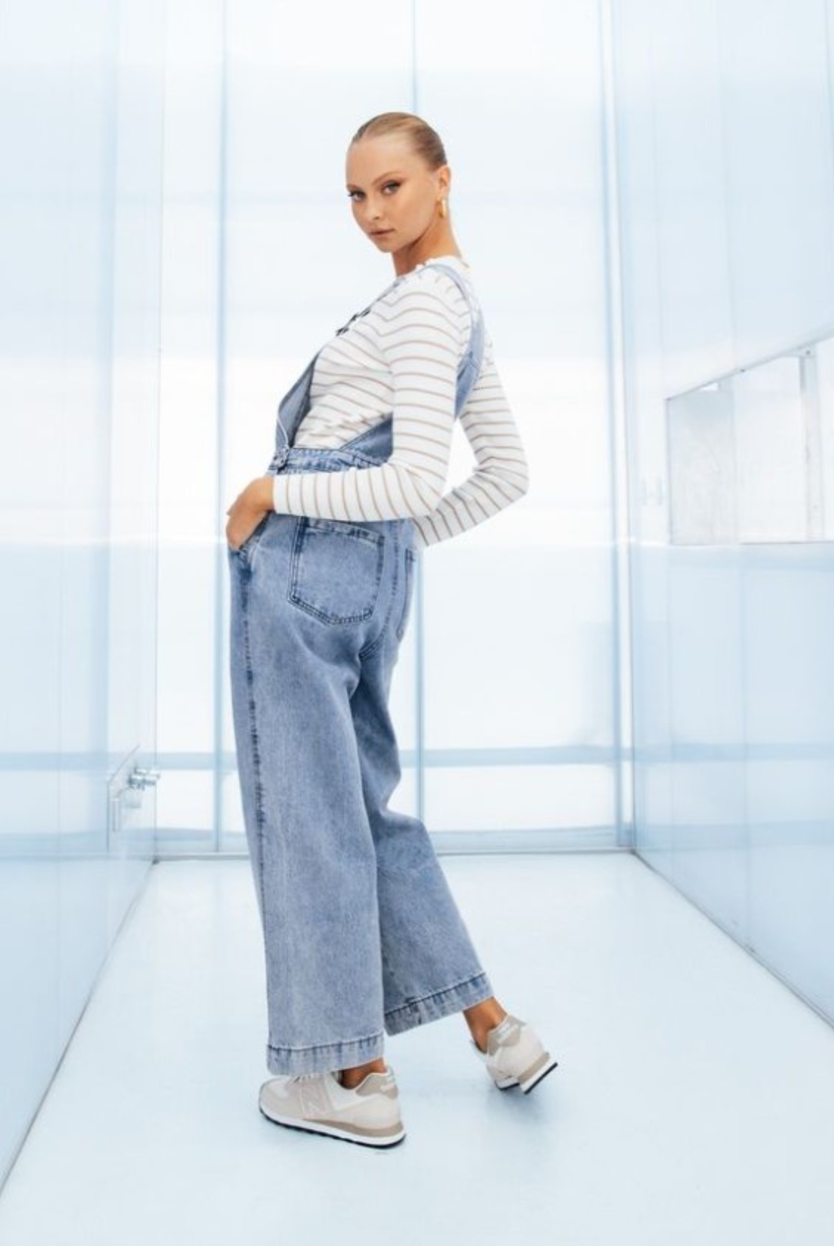 Model wearing lightwash denim overalls from paper heart