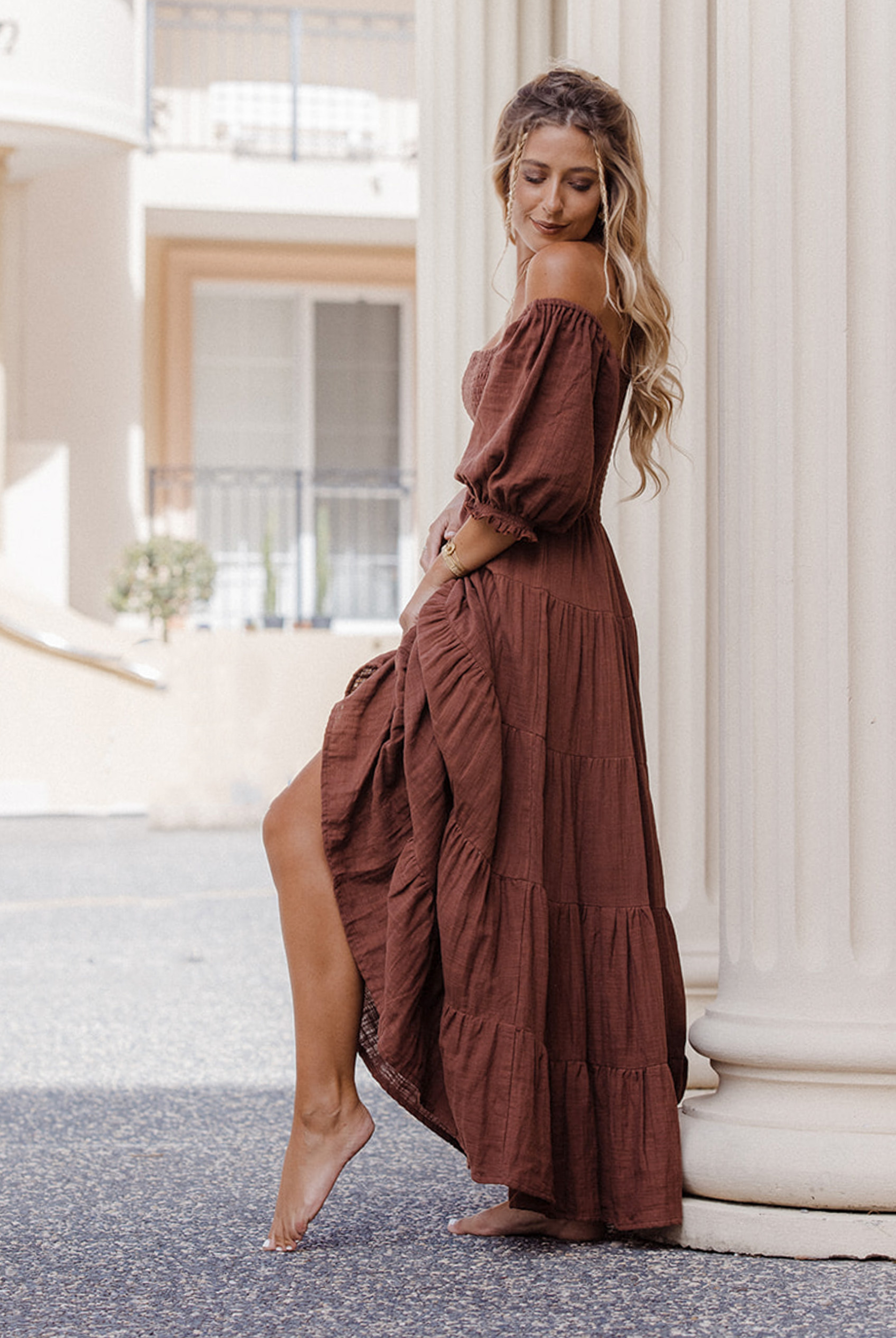 Model wearing chocolate brown tiered dress with short puffy sleeves