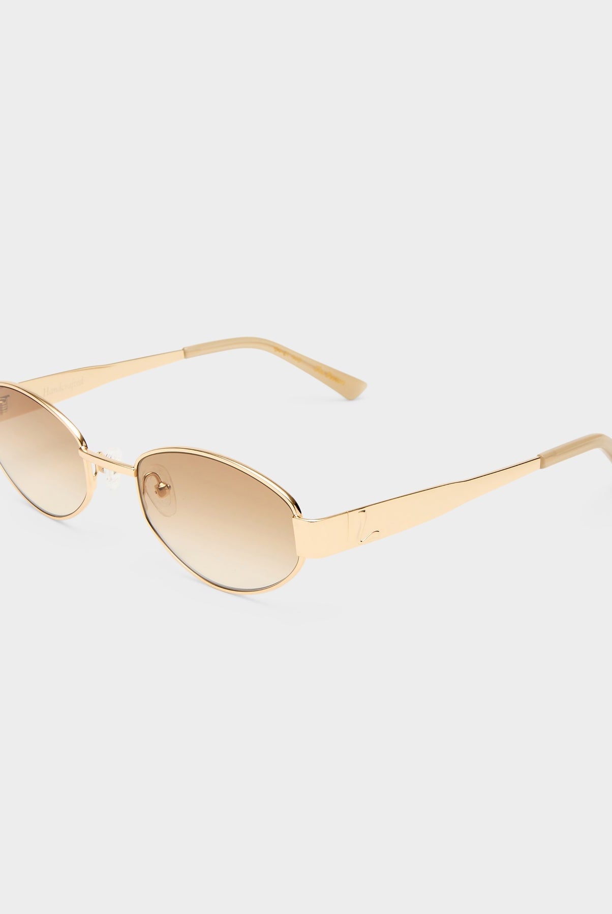 Gold-framed sunglasses with gold lenses on a white background