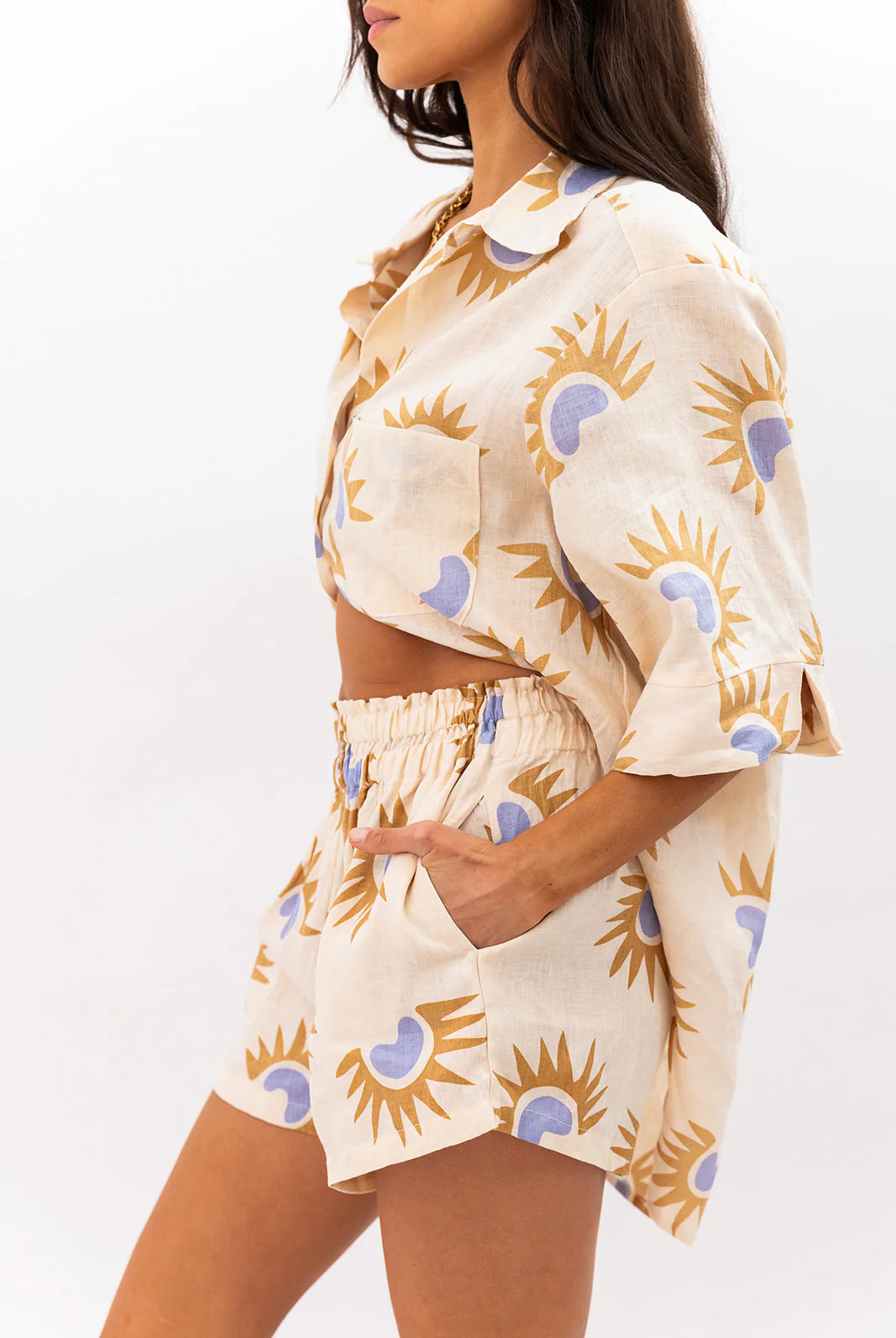 Woman wearing a matching top and shorts set with sunflower pattern on a white background