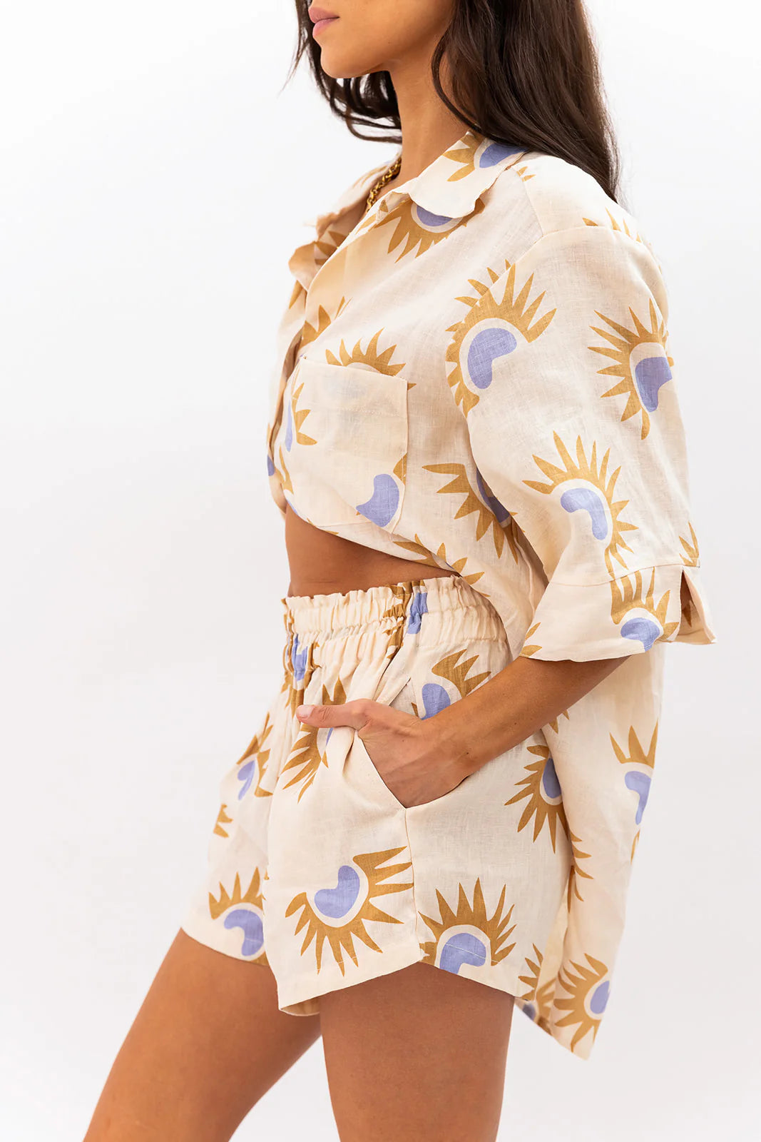 Woman wearing a matching top and shorts set with sunflower pattern on a white background