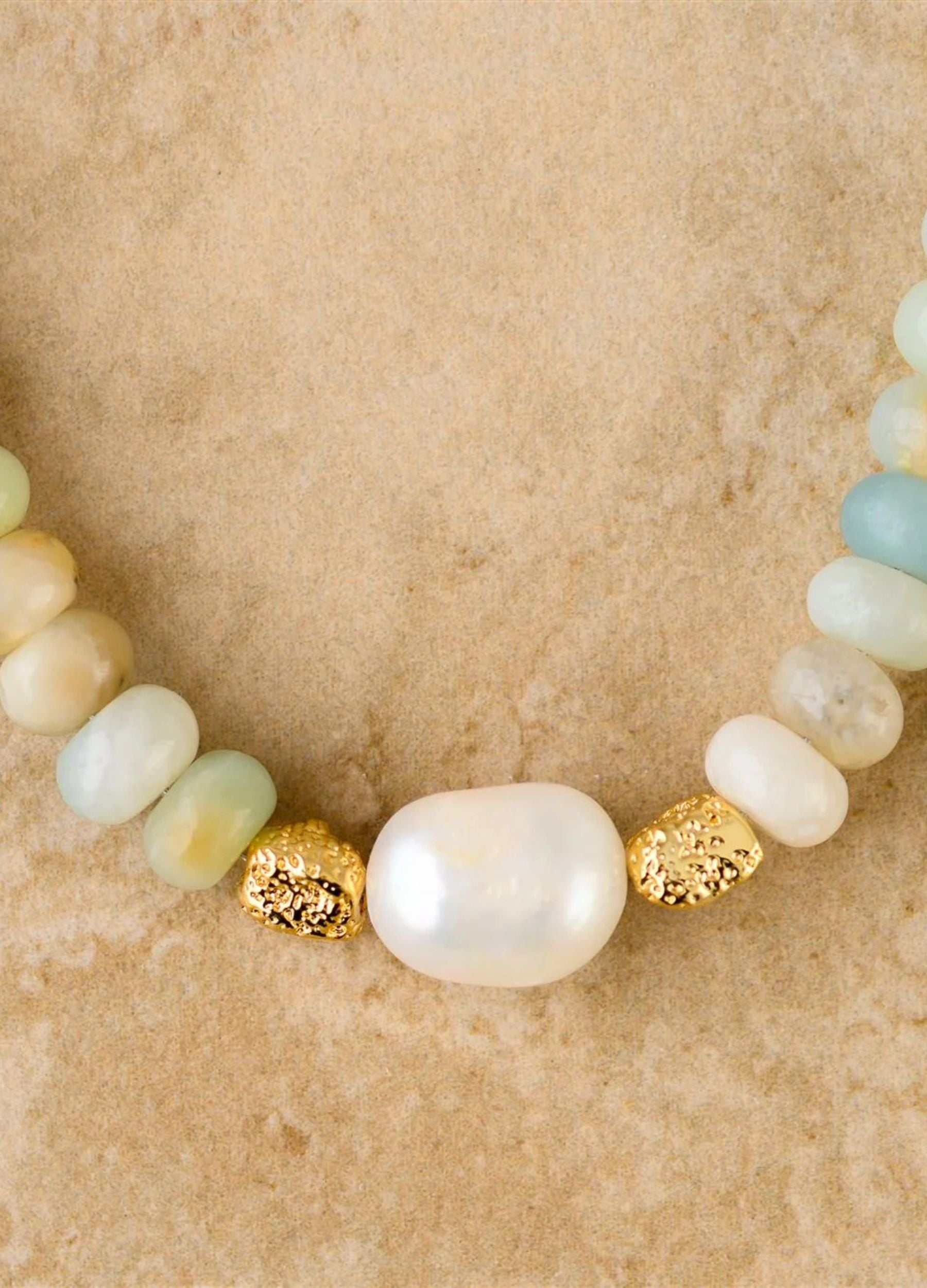 Necklace with pearls and gold accents on a beige background