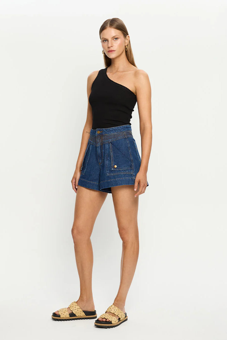 Woman wearing a black top and blue denim shorts on a white background