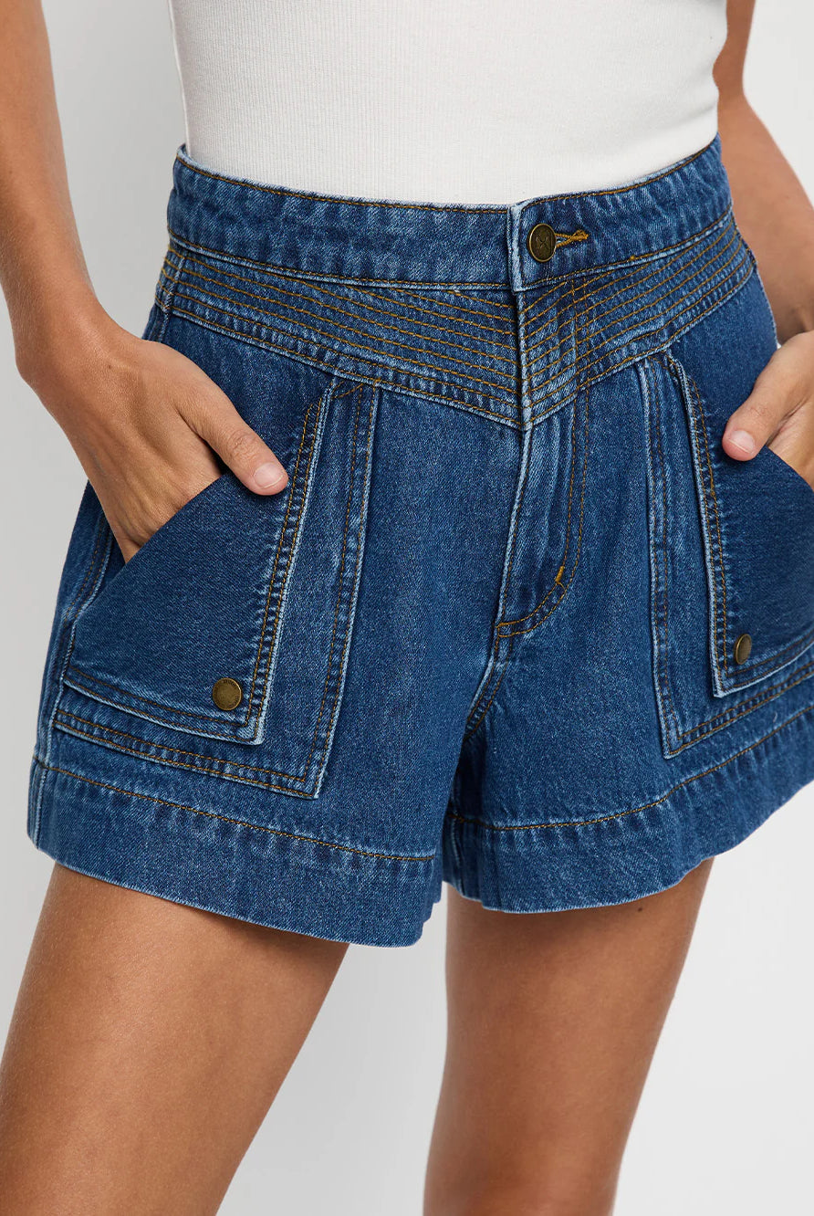 Blue denim shorts worn by a person on a white background