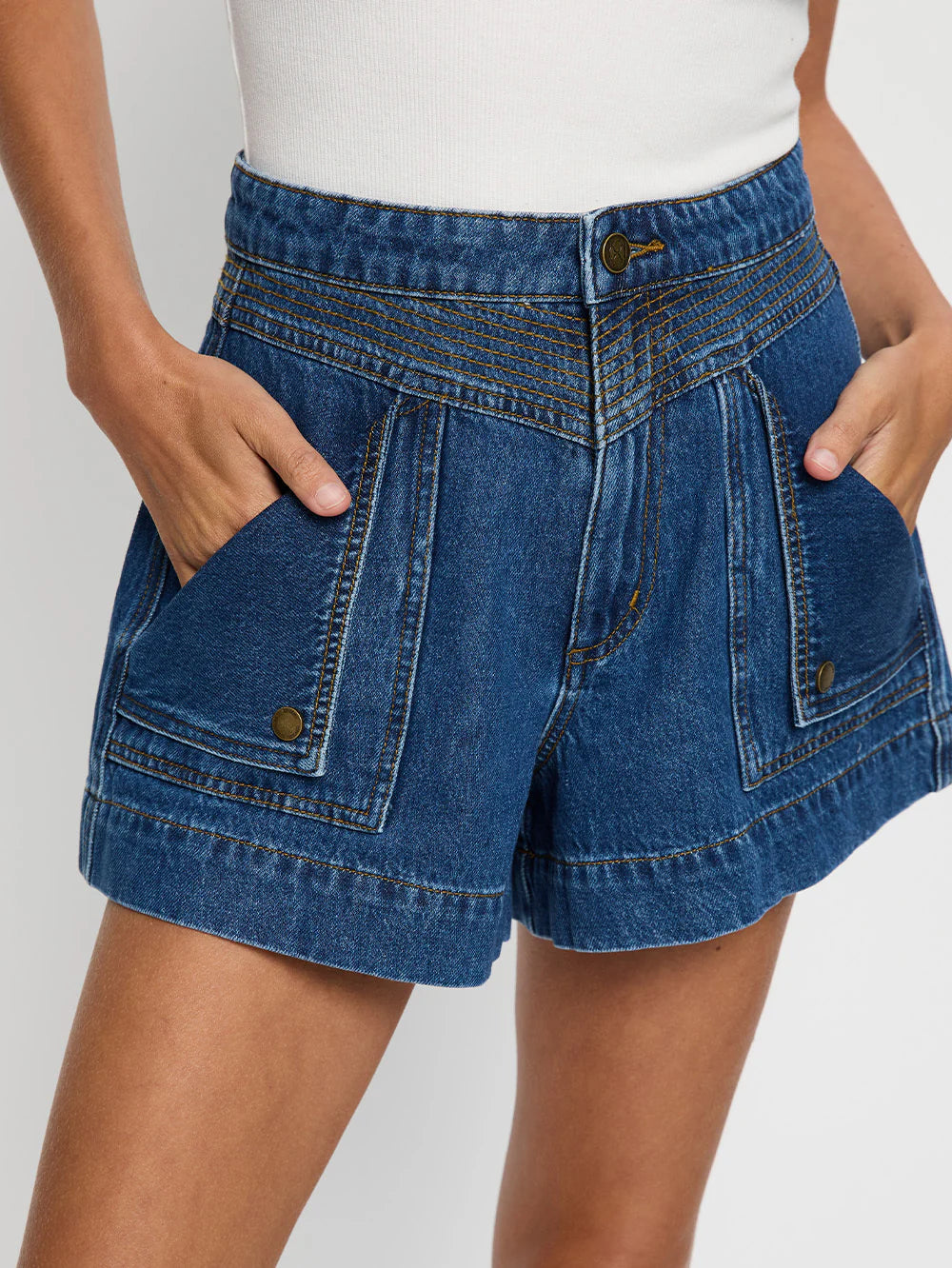 Blue denim shorts worn by a person on a white background