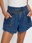 Blue denim shorts worn by a person on a white background