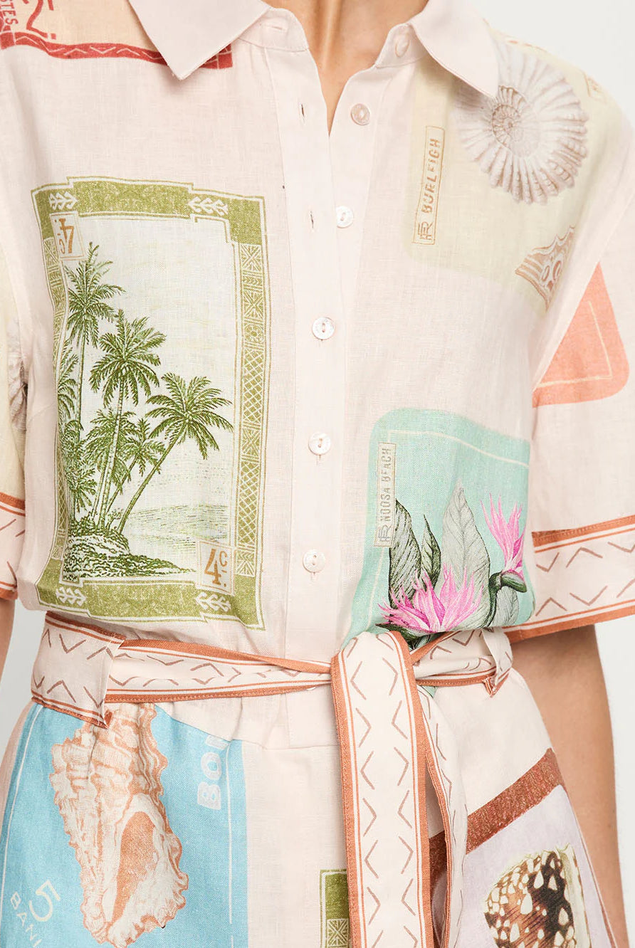 Close-up of a shirt with tropical-themed design featuring palm trees and shells.
