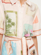 Close-up of a shirt with tropical-themed design featuring palm trees and shells.