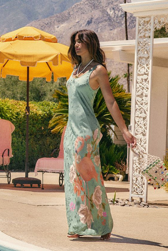 Woman in a floral dress standing outdoors with mountains in the background