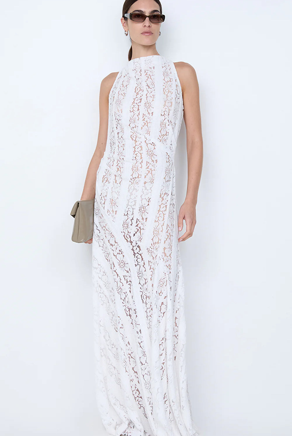 Woman wearing a white lace dress against a white background