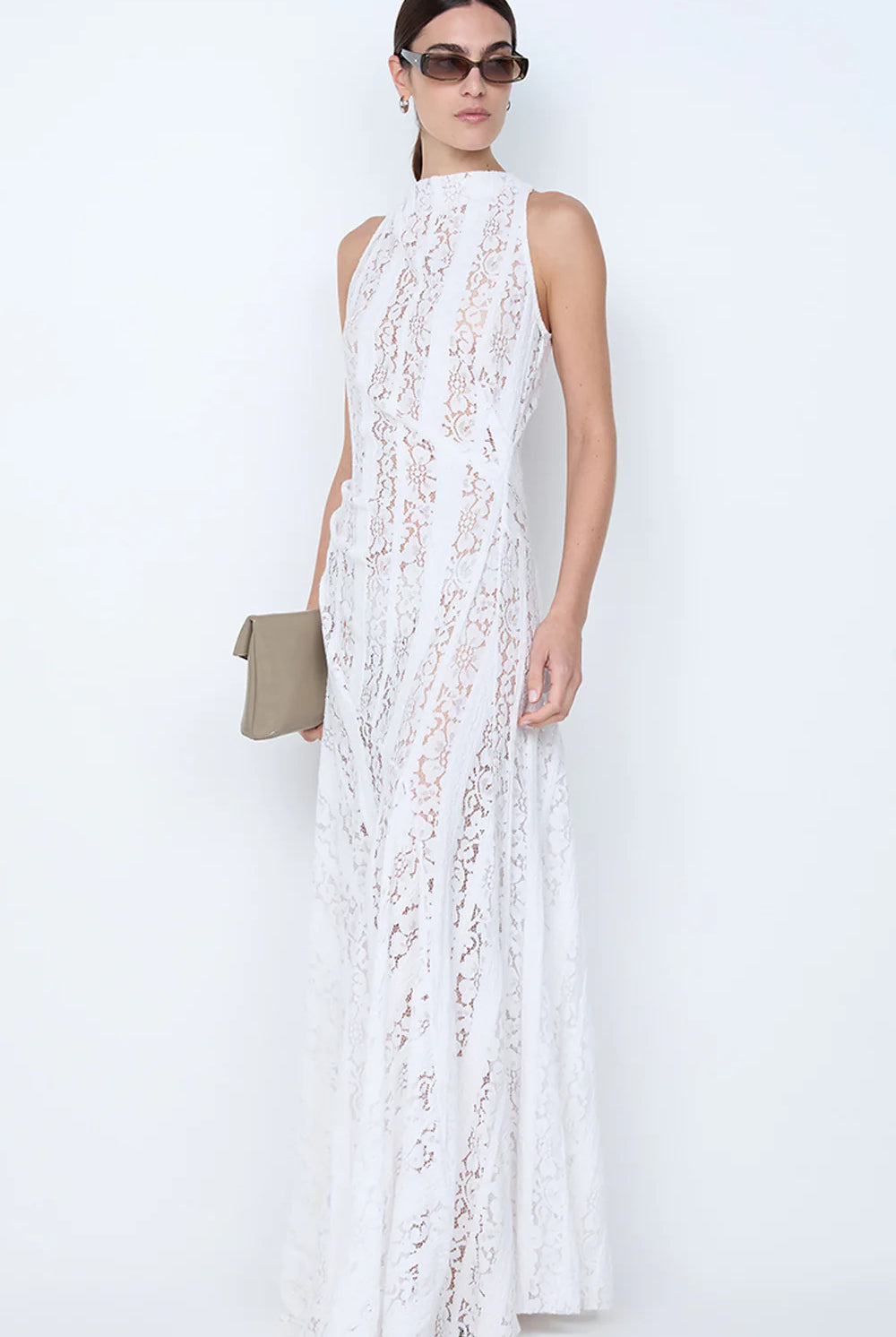 Woman wearing a white lace dress against a white background