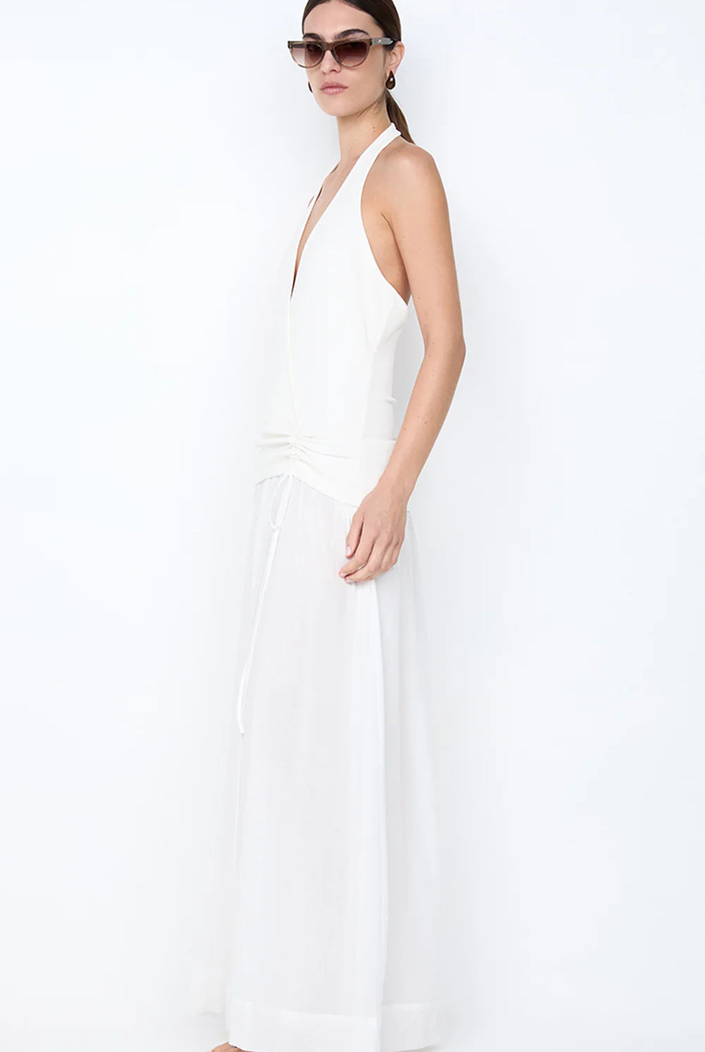 Woman wearing a white halter neck dress on a white background