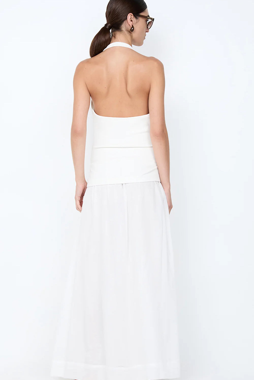 Woman wearing a white strapless dress against a white background