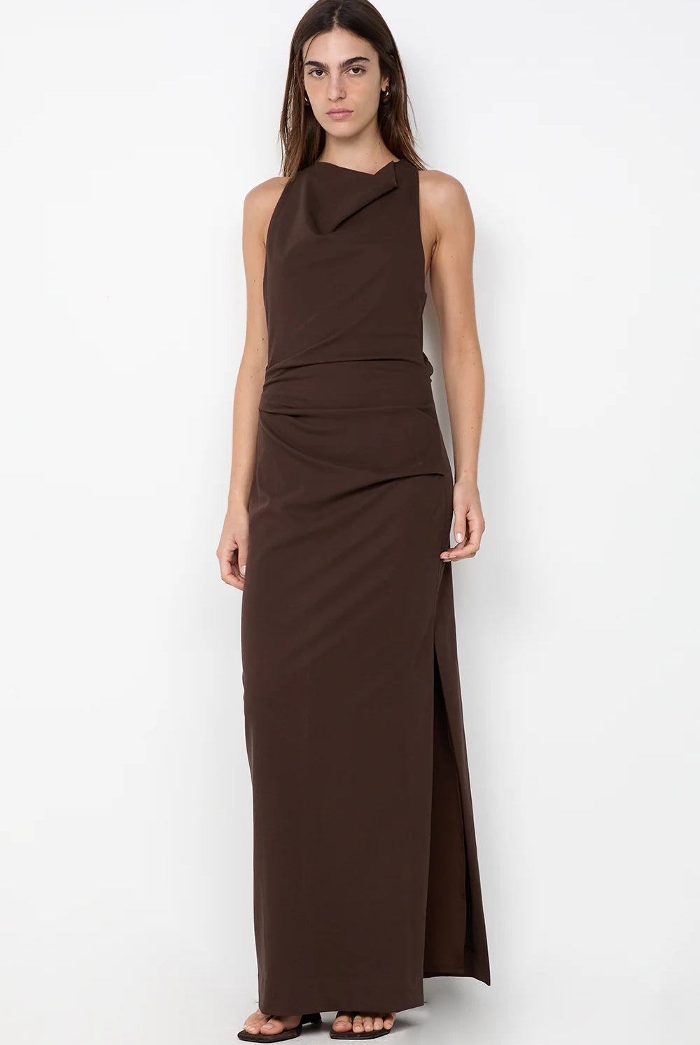 Woman wearing a brown halter neck dress on a white background