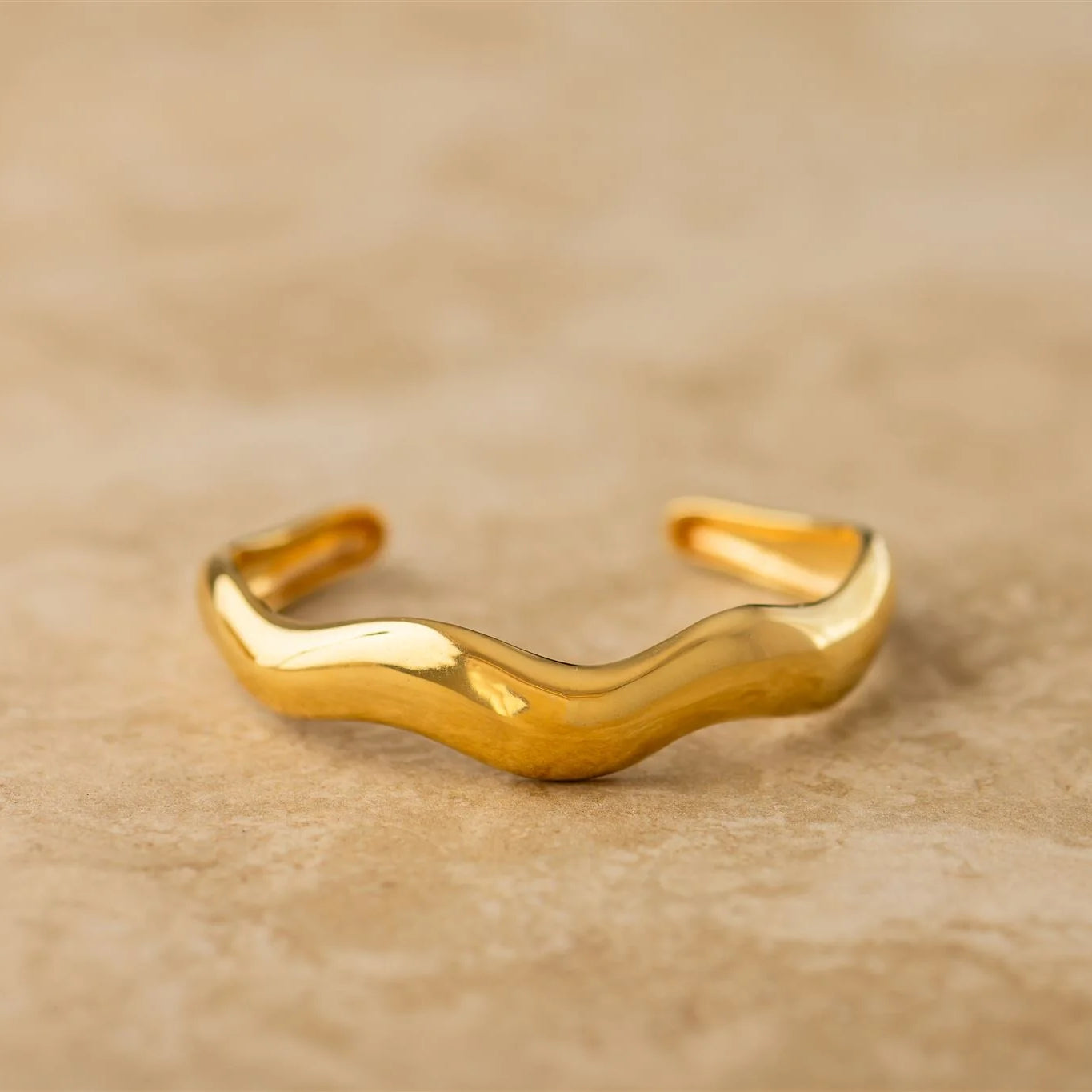 Gold bracelet on a beige background