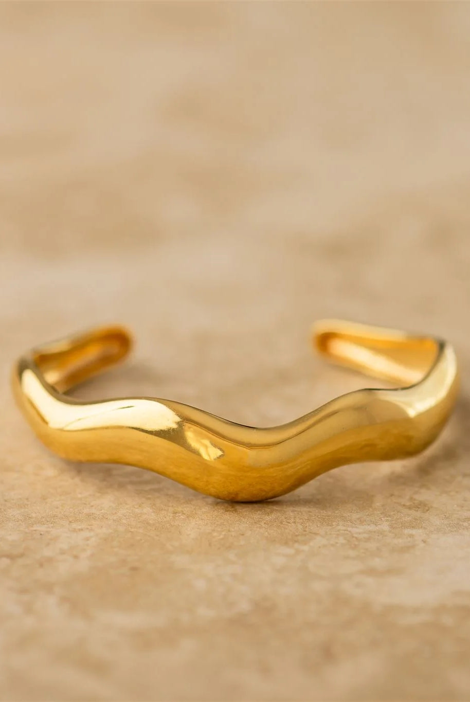 Gold bracelet on a beige background