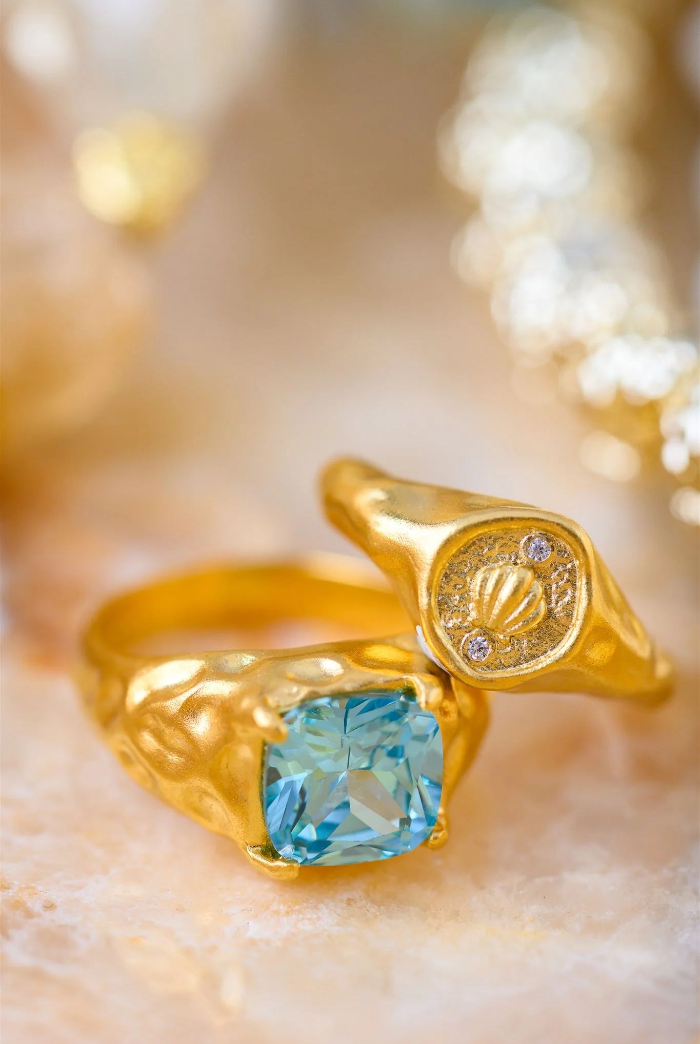 Gold ring with a blue gemstone on a blurred gold background