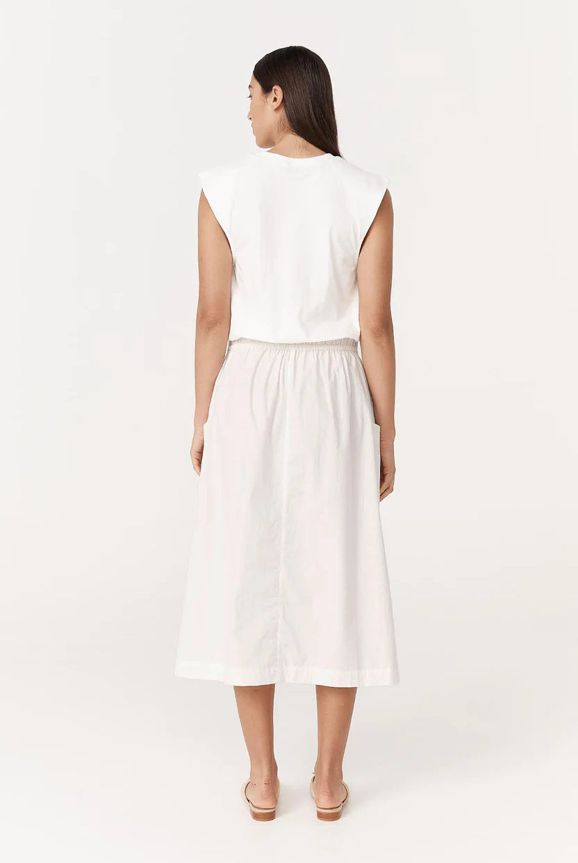 Woman wearing a white sleeveless top and skirt set on a white background