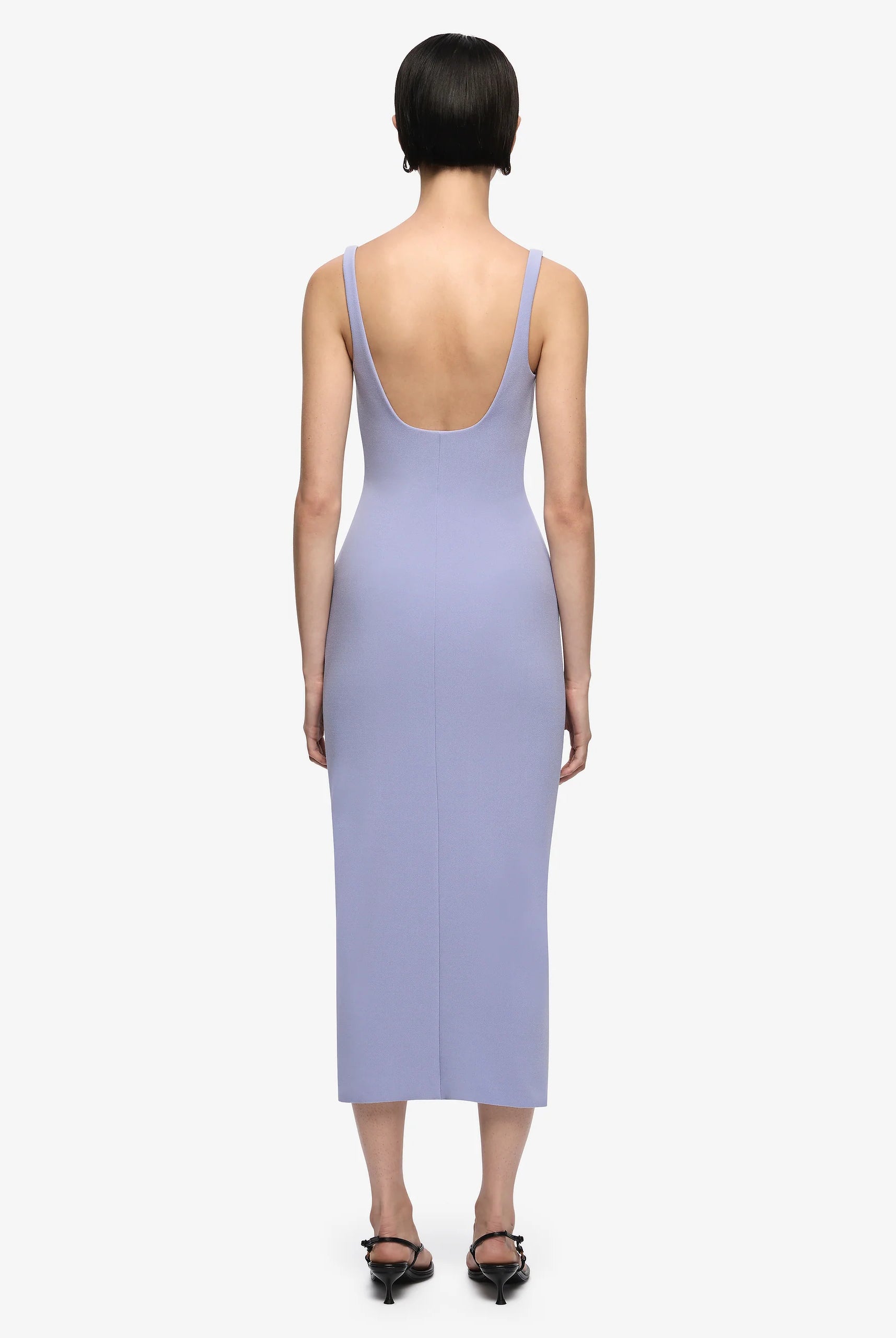 Woman wearing a light purple dress with a plain background