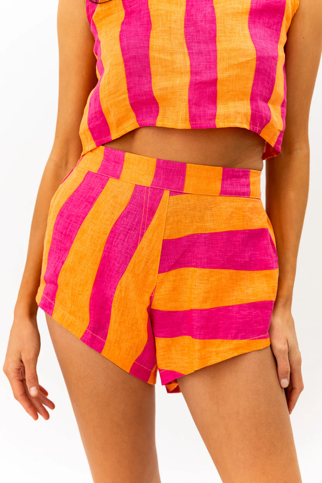 Person wearing a colorful striped outfit with pink and orange vertical stripes on a white background