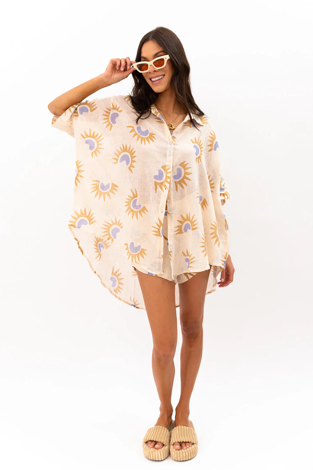 Woman wearing a patterned shirt dress on a white background