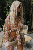 Woman wearing a floral kimono-style garment with a leopard print top, standing outdoors.