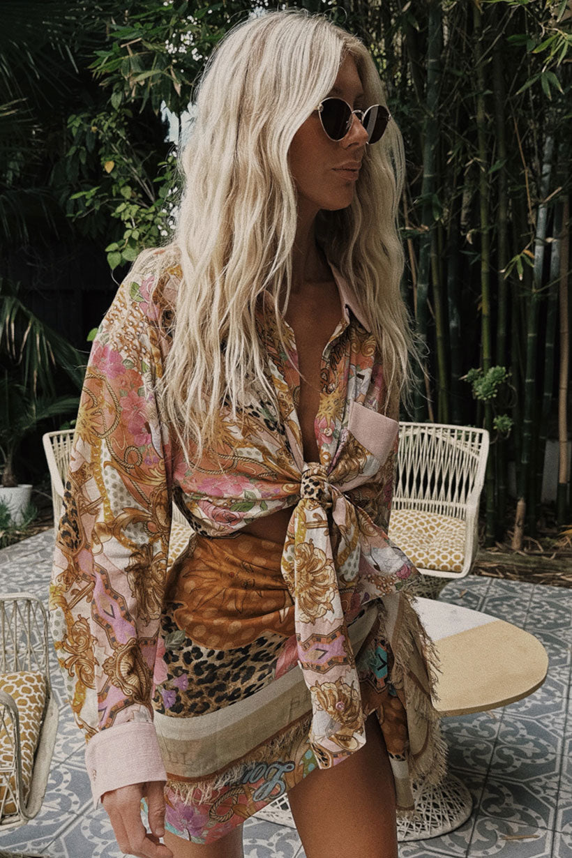 Woman wearing a floral kimono-style garment with a leopard print top, standing outdoors.