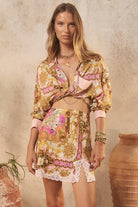 Woman wearing a floral outfit with a neutral background