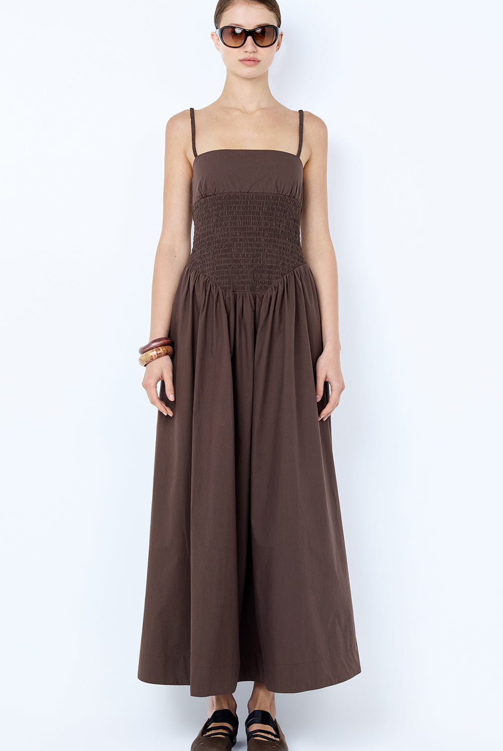 Woman wearing a brown sleeveless dress on a white background