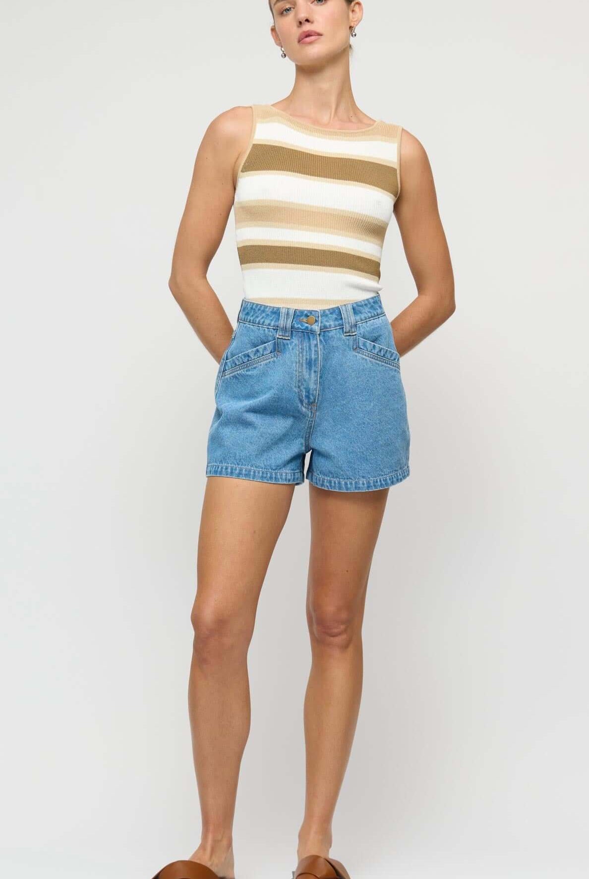 Woman wearing a striped top and denim shorts on a white background