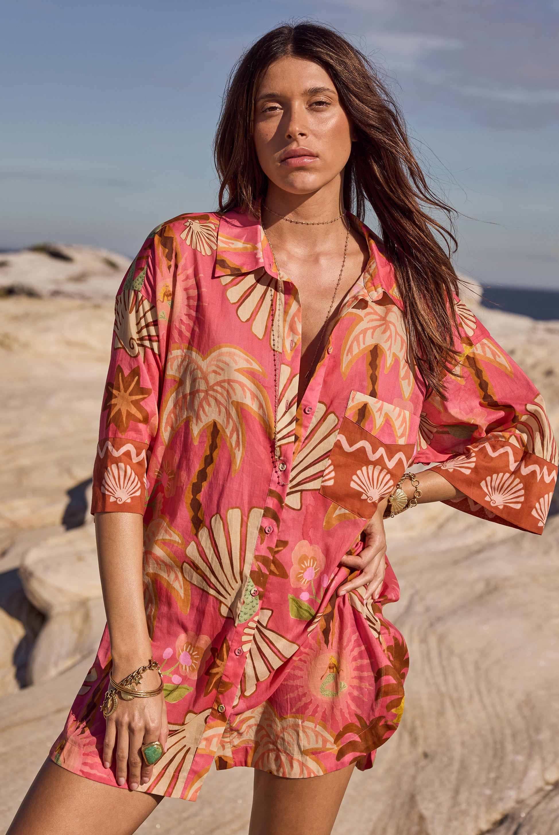 Woman wearing a pink floral dress on a beach