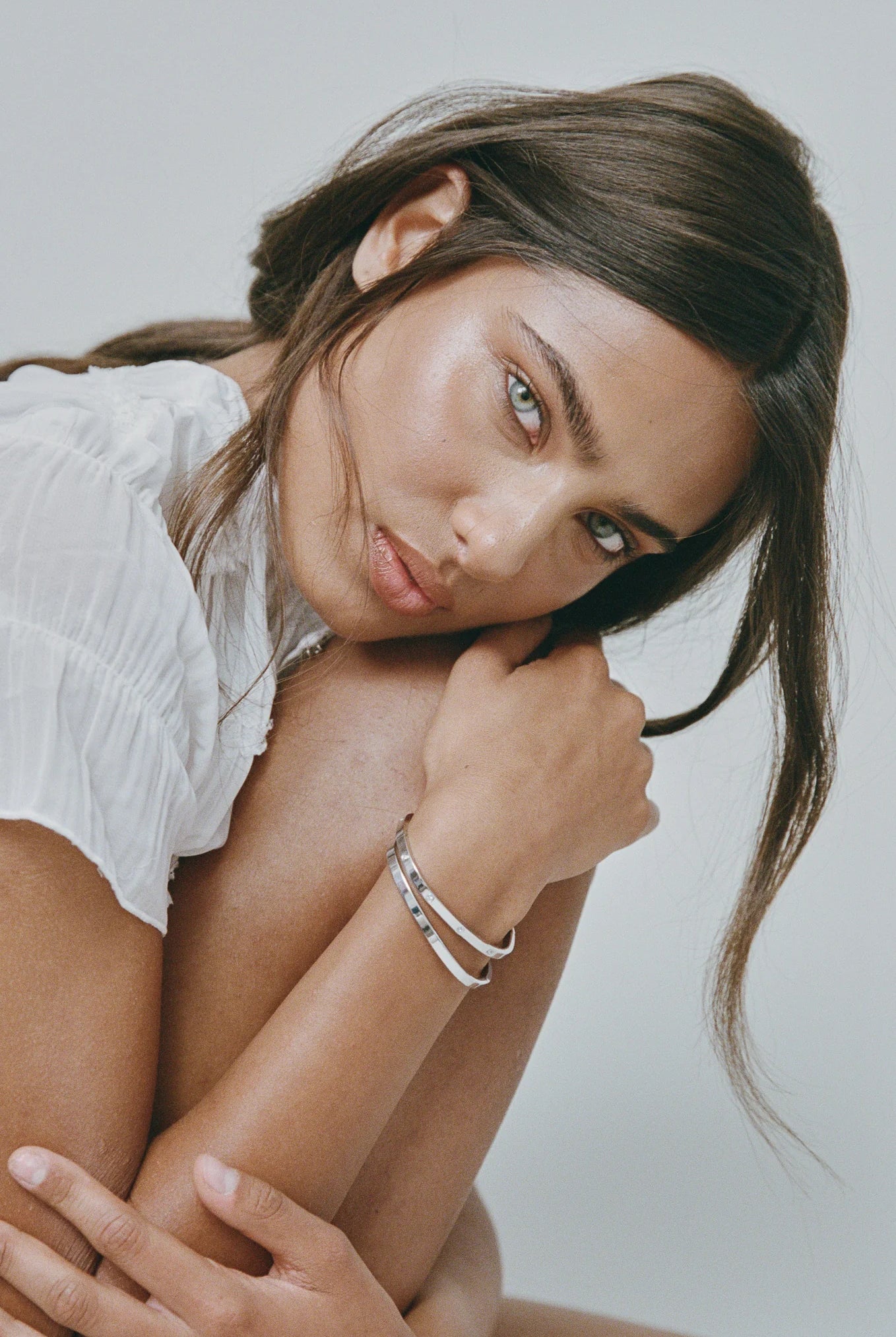 Woman wearing a white top with a neutral background