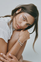 Woman wearing a white top with a neutral background