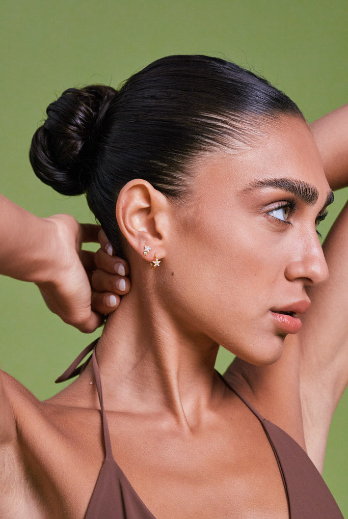 Woman with a bun hairstyle against a green background