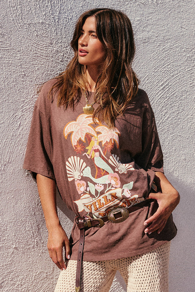 Rocky Barnes wearing a graphic t-shirt with a design on a textured wall