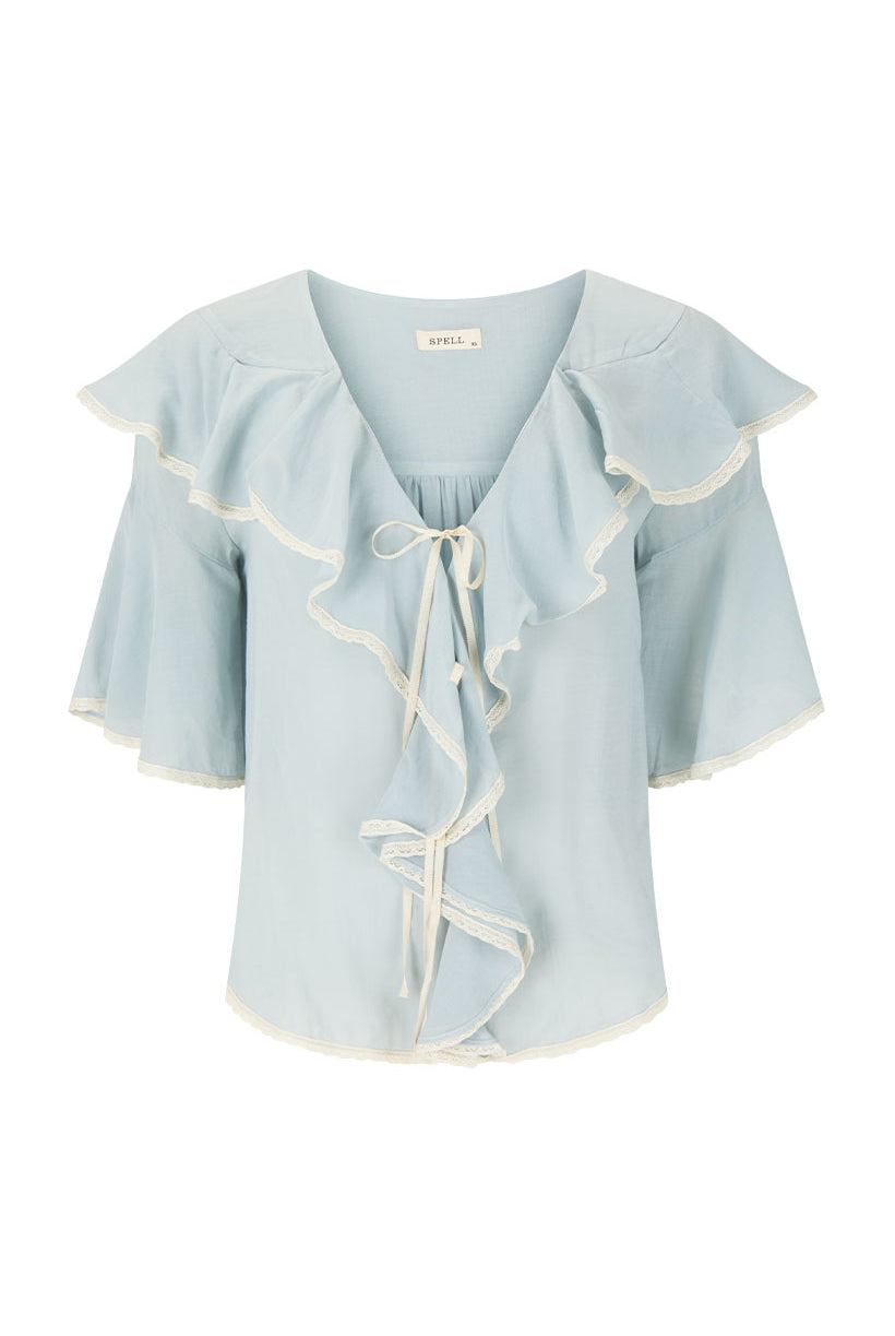 Light blue blouse with ruffled sleeves and neckline on a white background