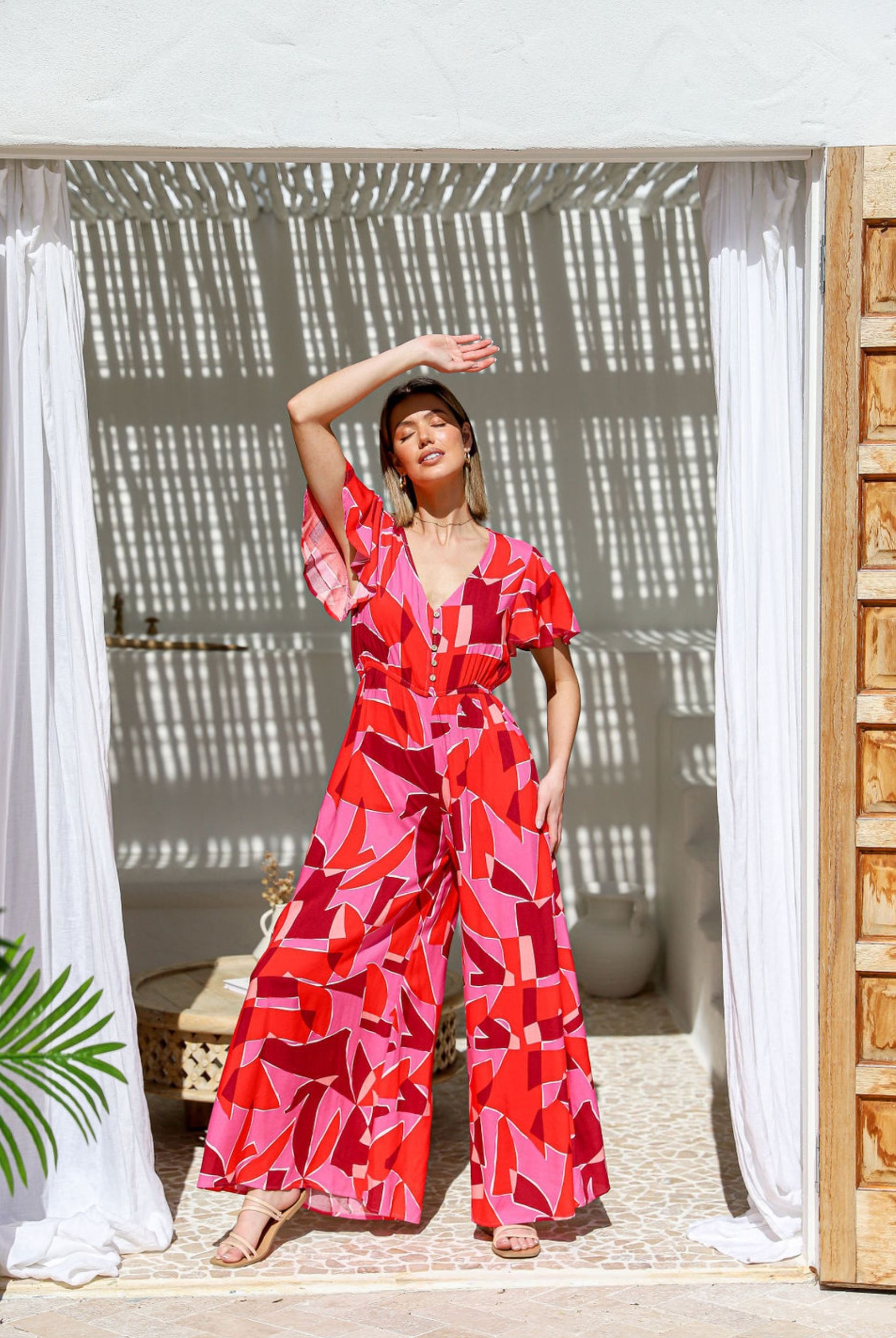 Brightly coloured geometric jumpsuit with coconut buttons