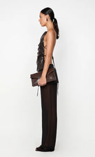 Woman holding a brown clutch bag against a white background