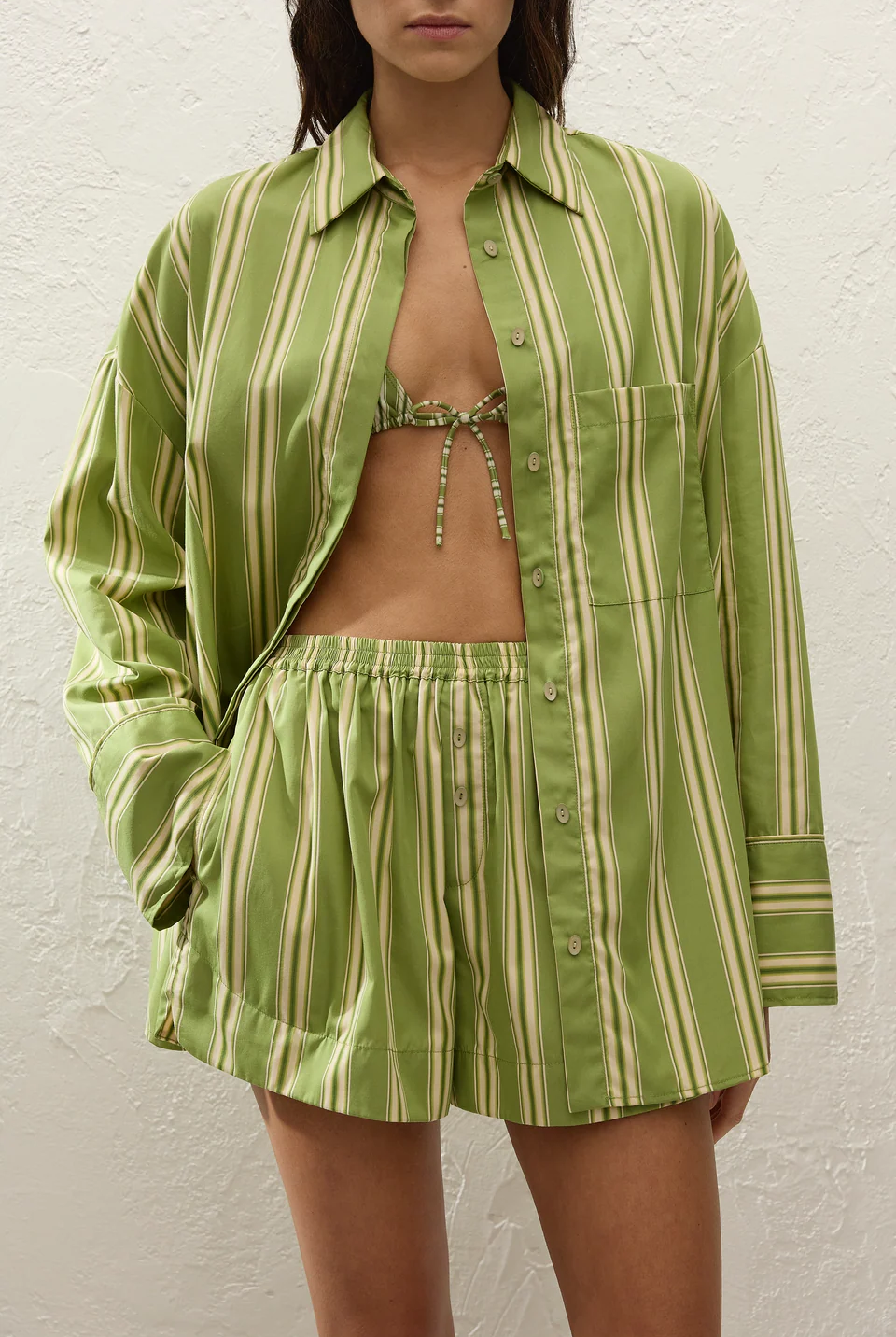 Person wearing a green and white striped outfit against a white background