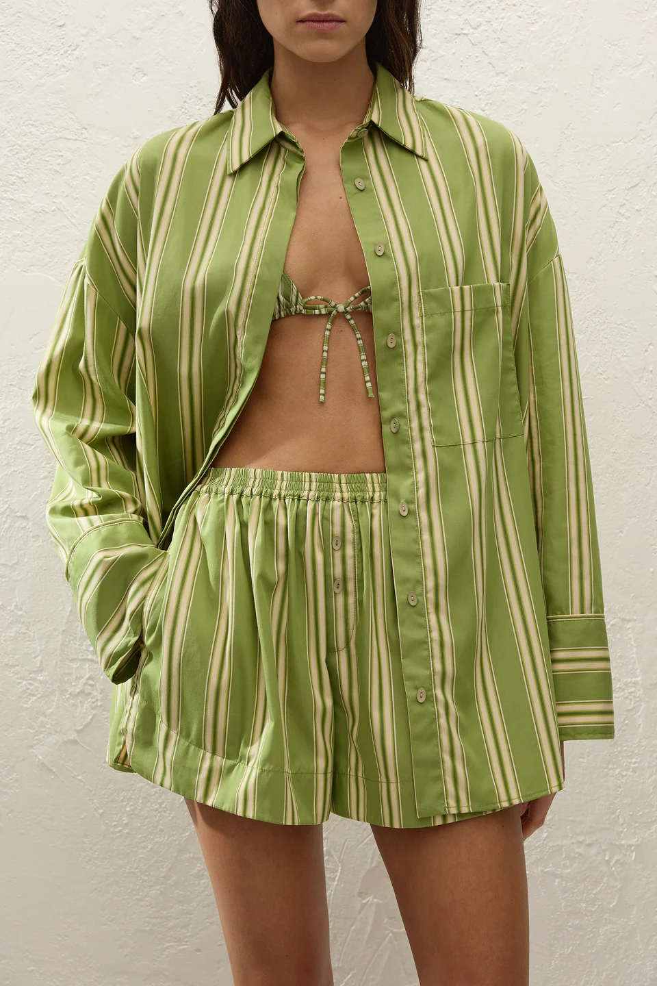 Person wearing a green and white striped outfit against a white background