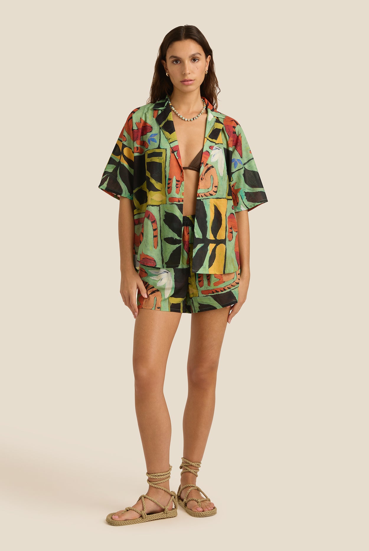 Woman wearing a colorful abstract patterned outfit on a beige background