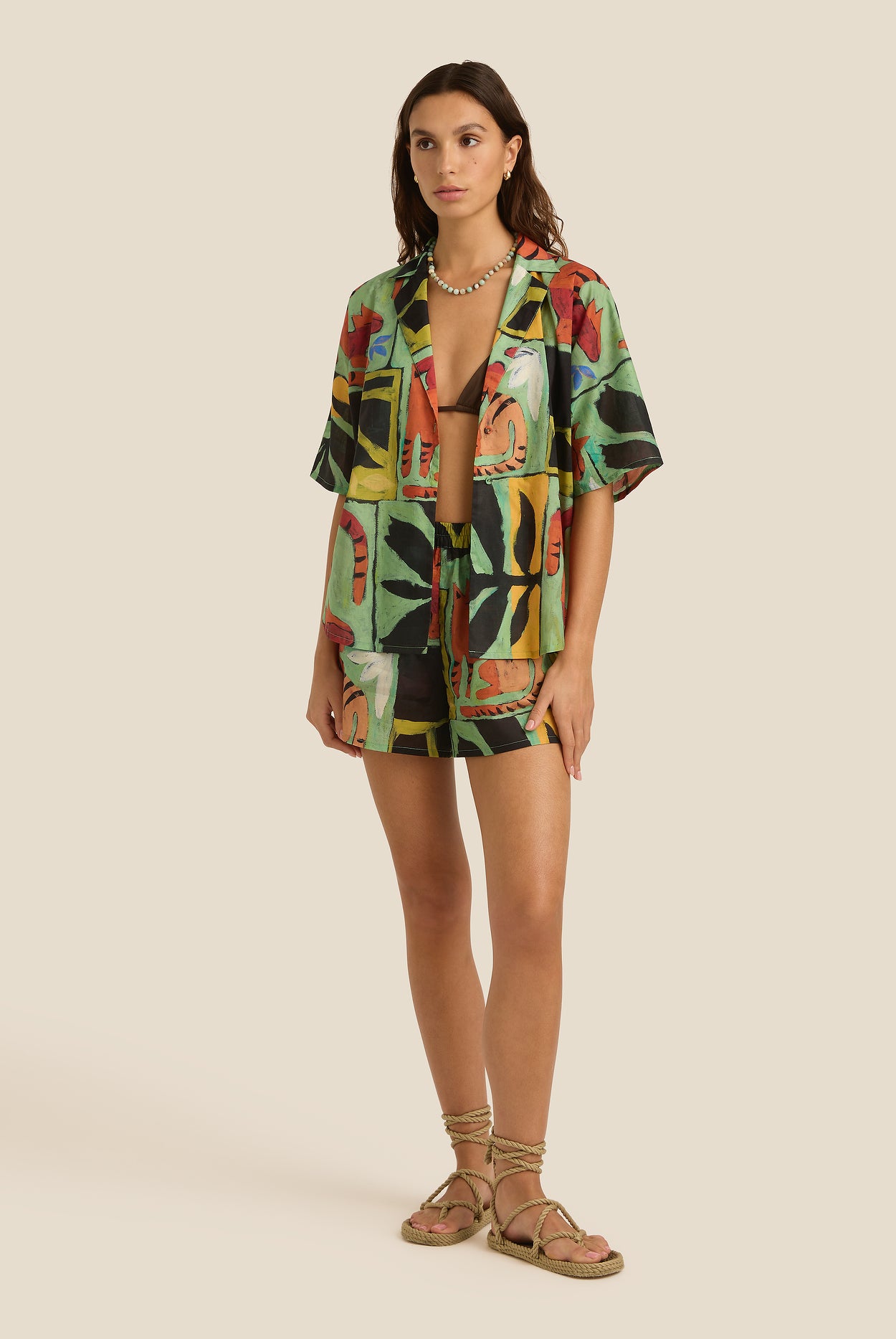 Woman wearing a colorful patterned outfit on a beige background