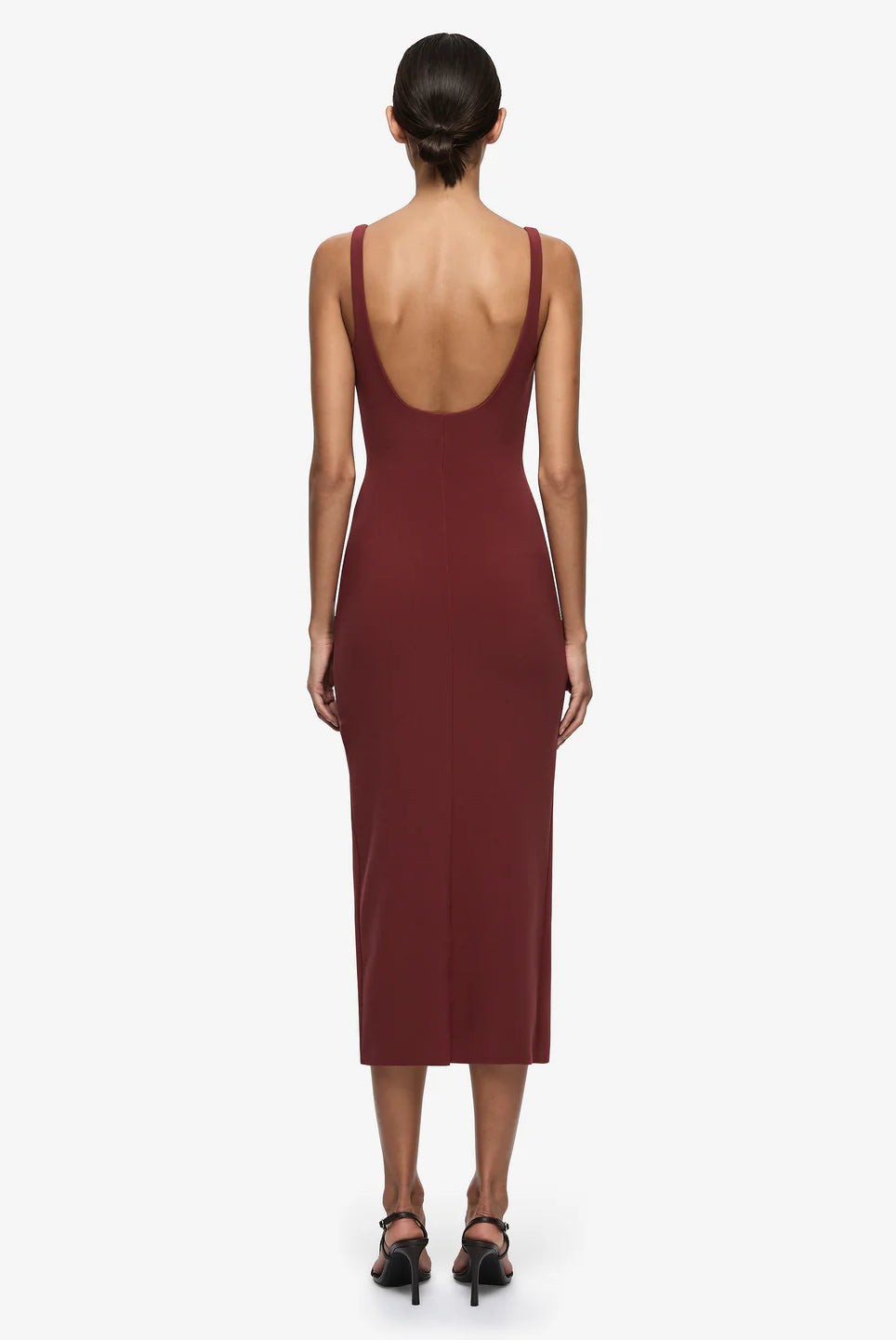 Woman wearing a burgundy dress with a deep neckline on a white background