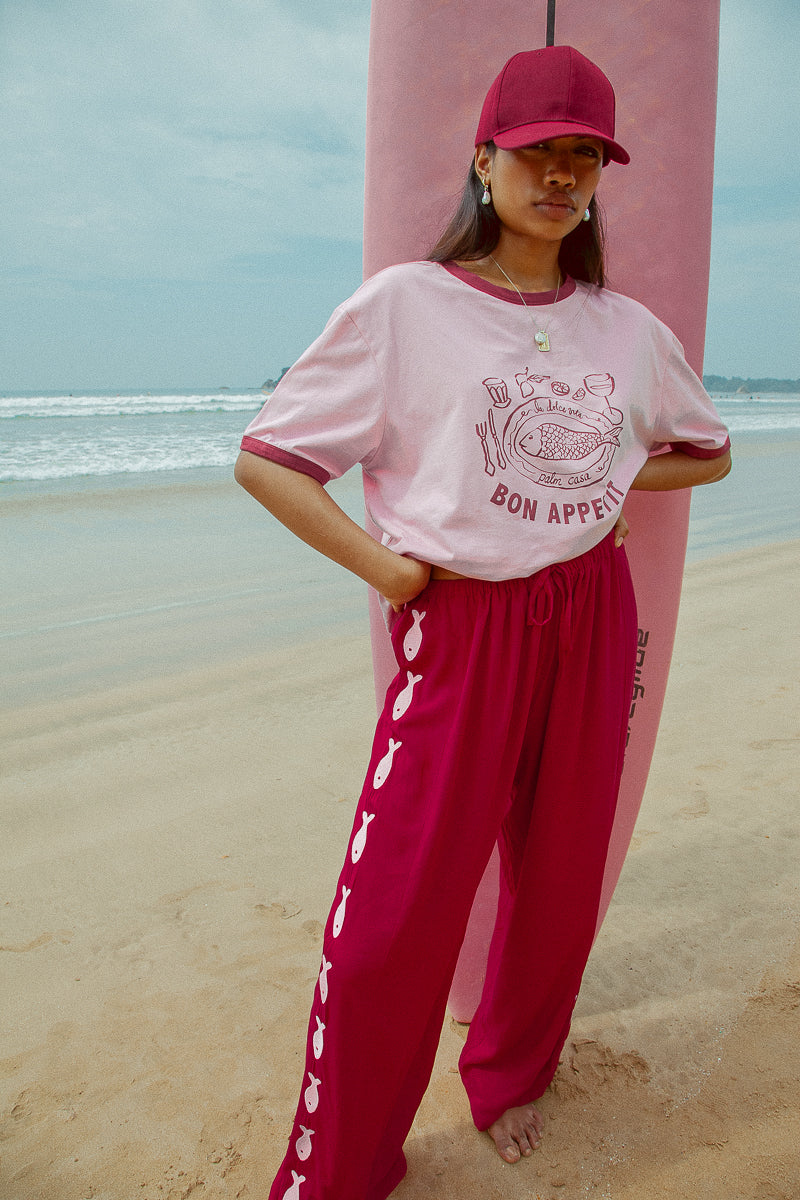 Deep red pants from Palm Collective with embroidered fish down the sides.