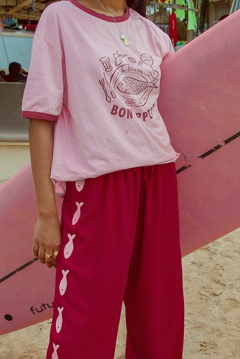 Deep red pants from Palm Collective with embroidered fish down the sides.